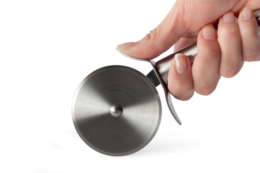 A hand holding a pizza cutter with a stainless steel blade on a white background